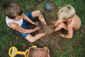 Toddlers playing in grass and mud